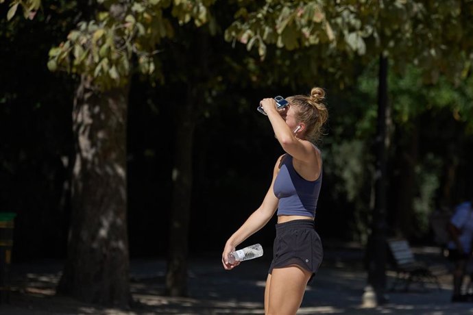 Archivo - Una mujer con una botella de agua en el parque de El Retiro durante una segunda ola de calor, a 23 de julio de 2024, en Madrid (Espa&ntilde;a).