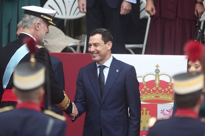 El rey Felipe y el presidente de la Junta de Andaluc&iacute;a, Juanma Moreno,  durante el acto solemne de homenaje a la bandera nacional y desfile militar por el 12 de octubre, D&iacute;a de la Hispanidad, en la Plaza de C&aacute;novas del Castillo, a 12 de octubre de 2025, e