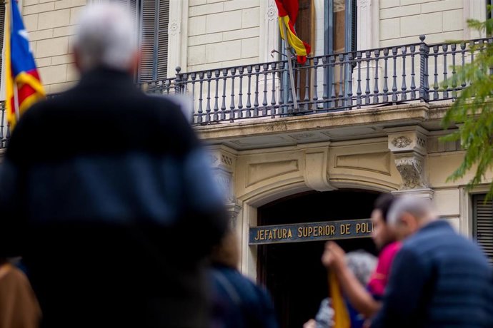 Archivo - Varias personas durante una concentración convocada por ANC y Comissió de la Dignitat, frente a la Jefatura de Policía Nacional de Via Laietana, en una imagen de archivo